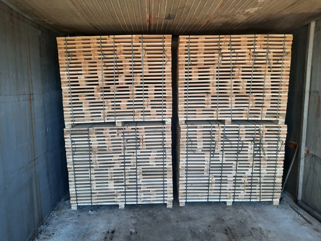 Packs of hardwood boards stacked with spacers in a kiln chamber