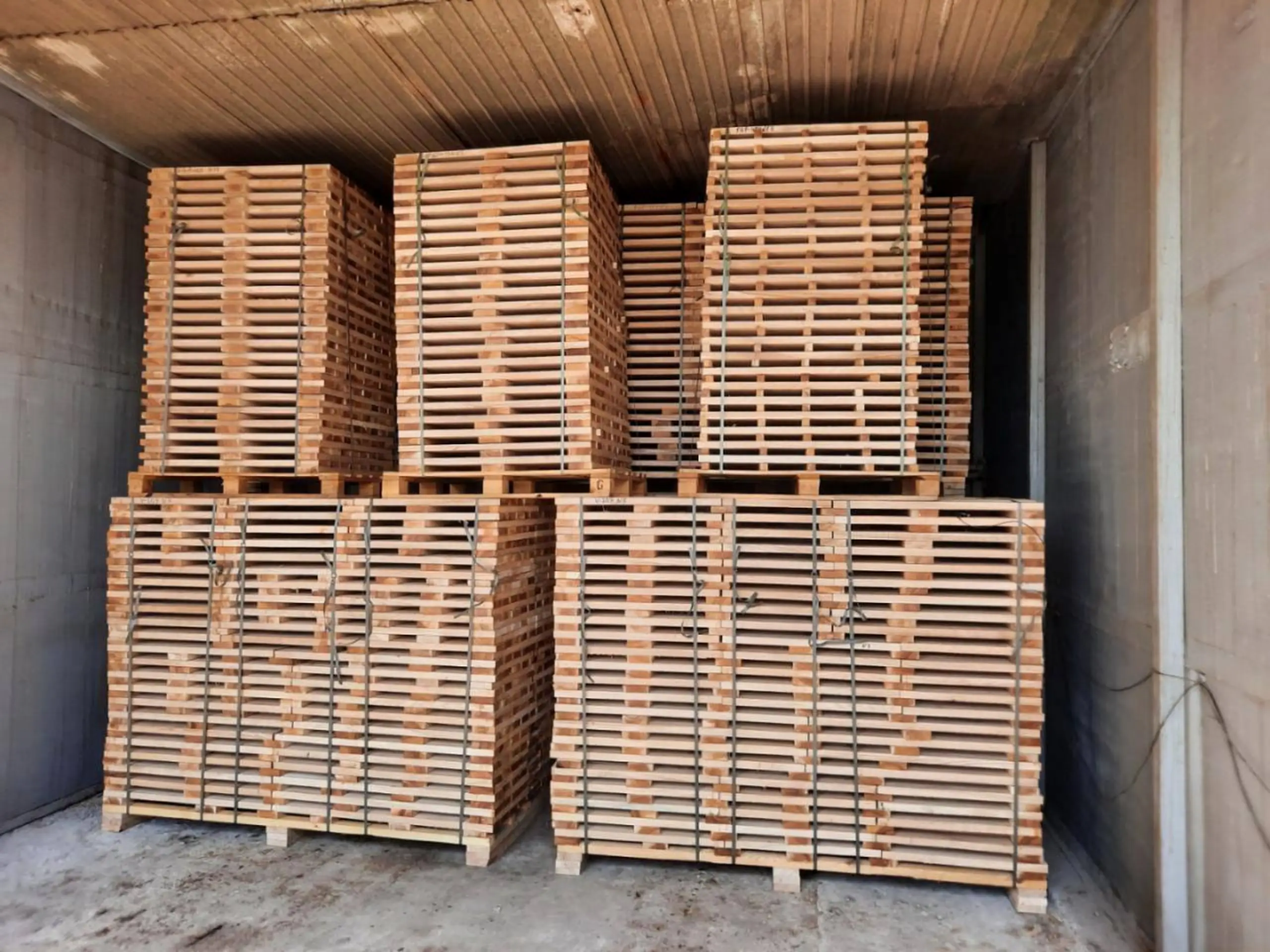 Packs of freshly sawn hardwood boards stacked in a kiln chamber