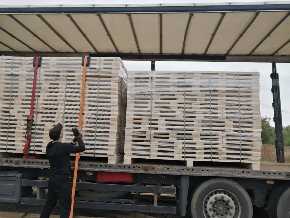 Packs of VK Timber hardwood boards strapped down on a curtain-side truck before departure